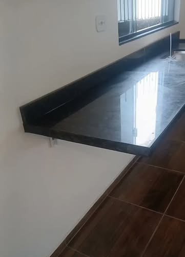 Bancada flutuante em granito polido junto à janela